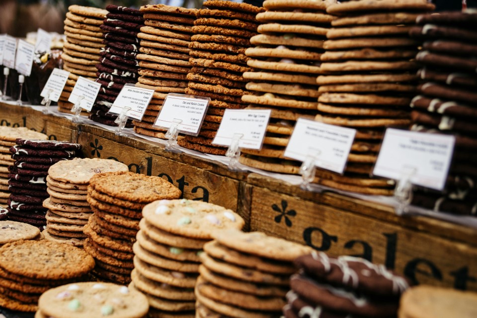 biscuits-artisanaux-pexels-conojeghuo Étals remplis de biscuits artisanaux empilés, prêts à être dégustés.