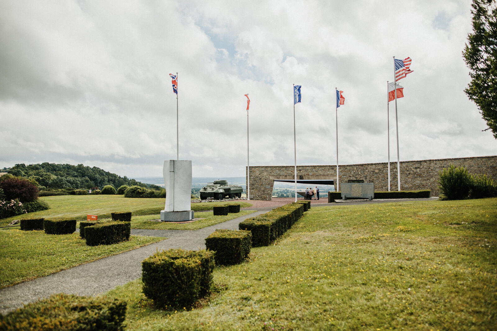 memorial-montormel-bataille-falaise-coraline-et-leo Mémorial de Montormel avec drapeaux et blindé en arrière-plan.