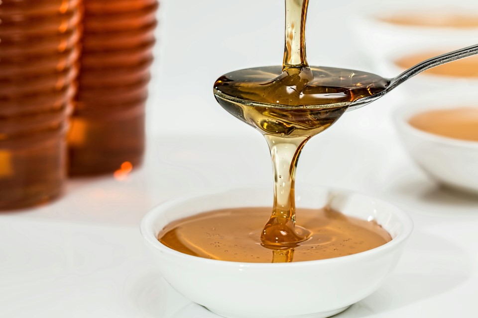 miel-coulant-abeilles-credit-pexels-pixabay Cuillère de miel doré qui coule dans un bol.