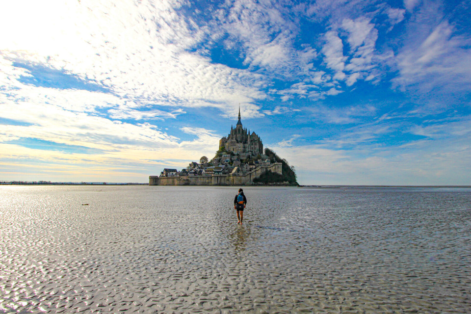 mont-saint-michel-baie-a-pied-sophie-kernen Un marcheur traversant la baie en direction du Mont-Saint-Michel.