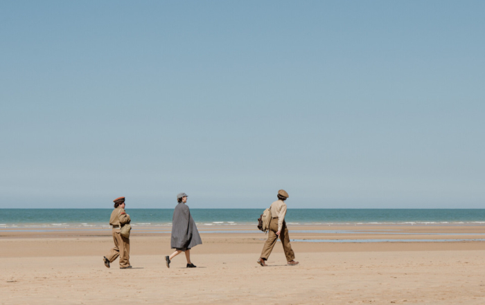 Personnes en tenue historique marchant sur la plage d’Omaha à Saint-Laurent-sur-Mer.