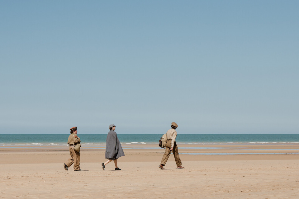 plage-omaha-saint-laurent-sur-mer-marie-anais-thierry Personnes en tenue historique marchant sur la plage d’Omaha à Saint-Laurent-sur-Mer.