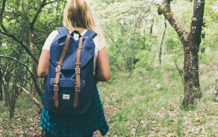 Jeune femme avec un sac à dos en randonnée dans une forêt normande.