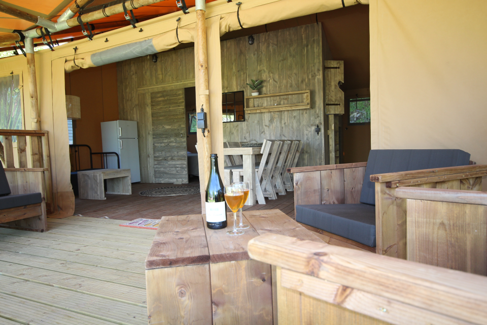 Terrasse et salon d'un chalet toilé woody luxe 8 personnes.